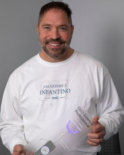 Dr. Salvatore Infantino holding GLO Teeth Whitening in Pittston, PA